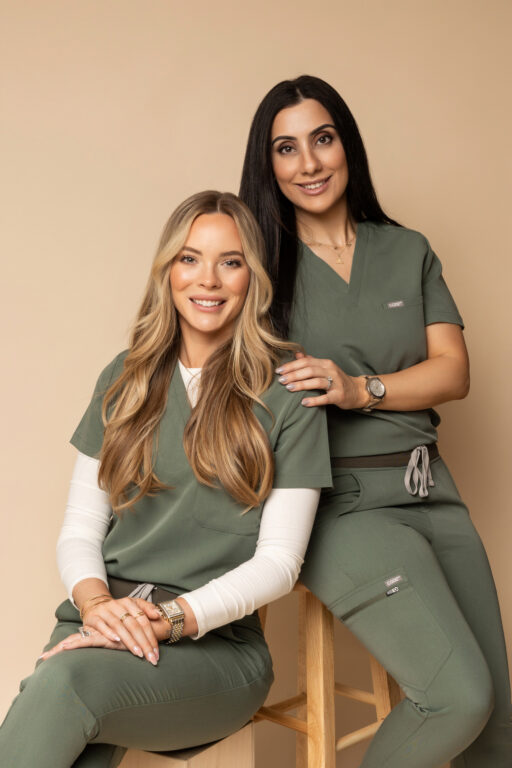 Two women sitting and smiling directly into camera.