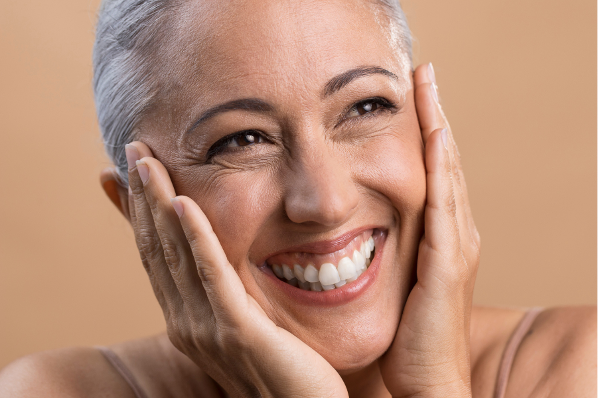 Woman smiling and holding her face.