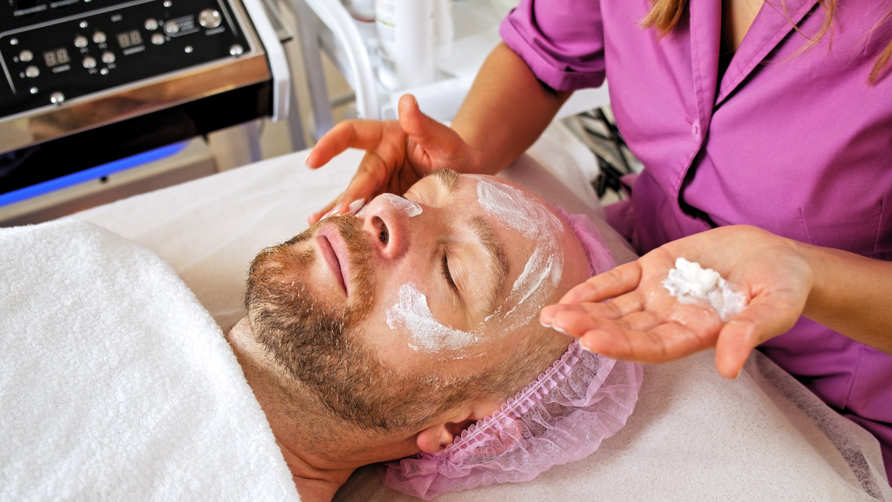 Image of a male patient at Exhibit Medical Aesthetic receiving a facial as part of our men's wellness clinic in Denville. 