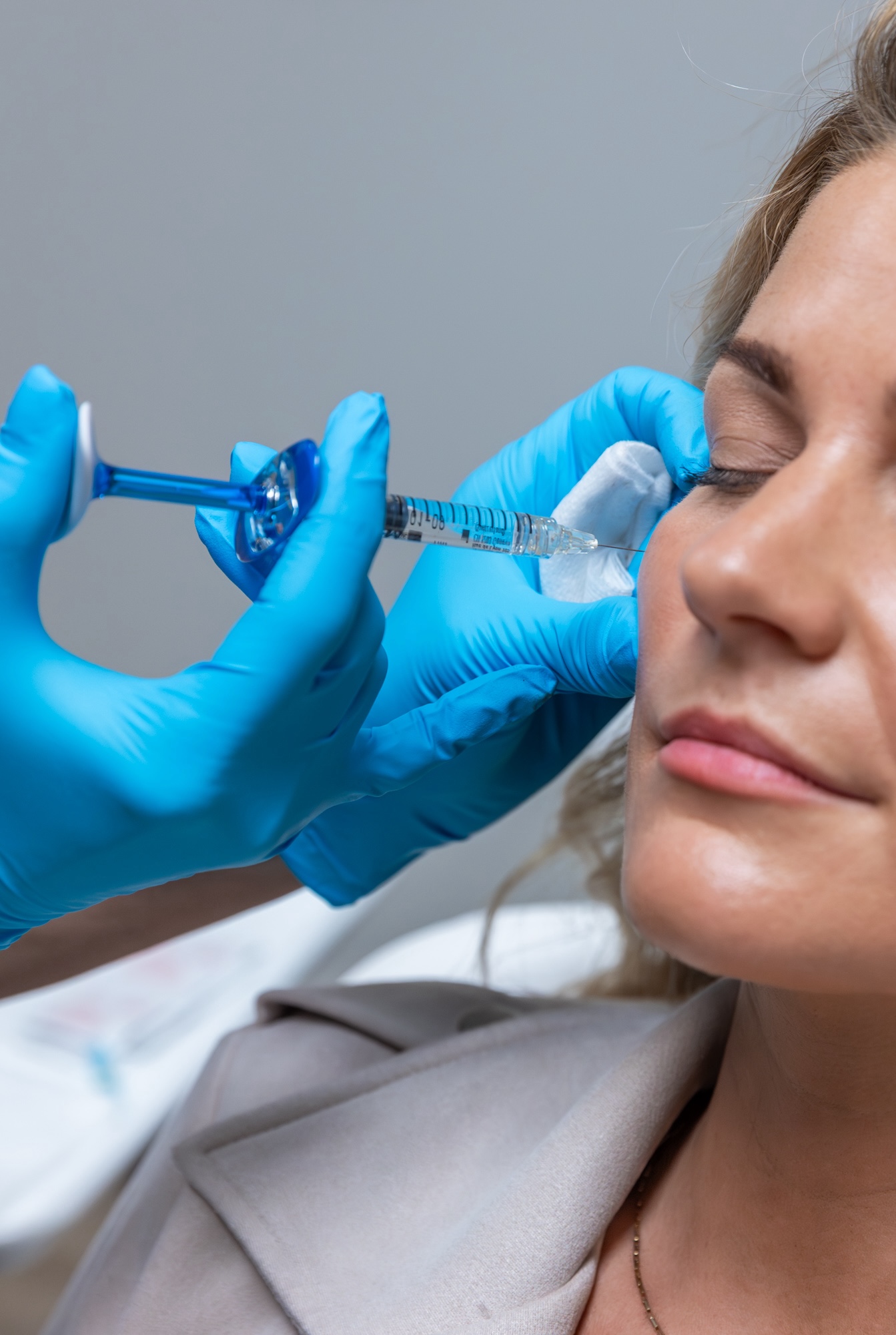 Shot of nurse inserting needle into patient's cheek.