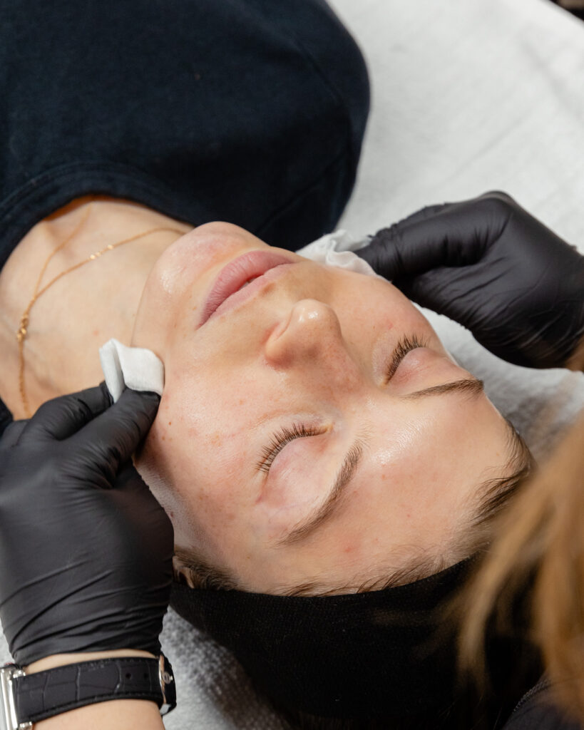 Nurse holds towel ends on patient's face