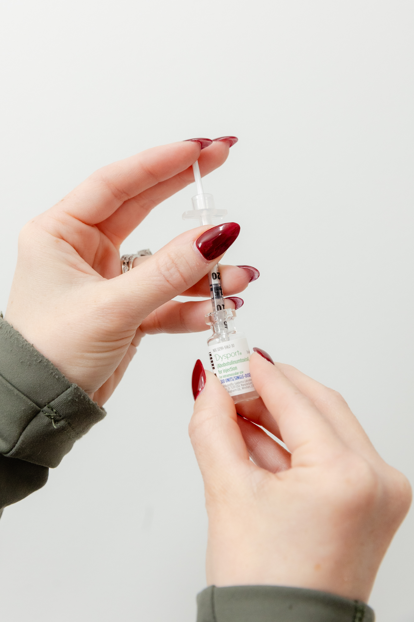 Photo of hands holding Dysport bottle and syringe