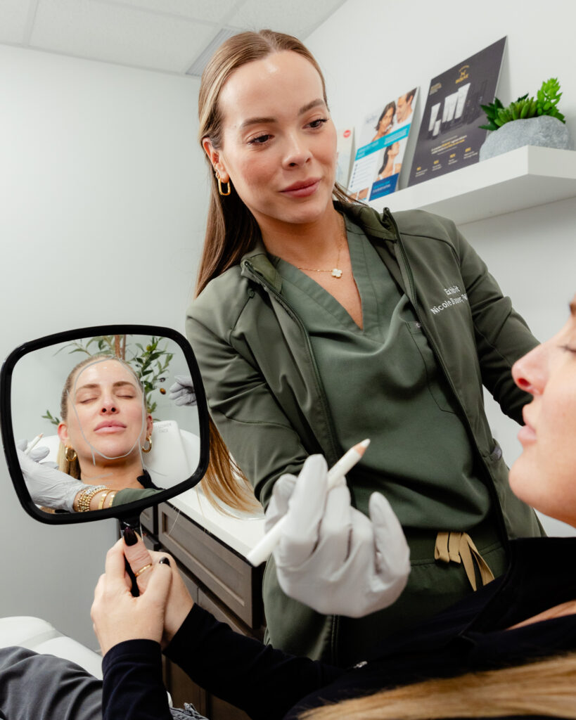 Nurse stands over woman holding mirror