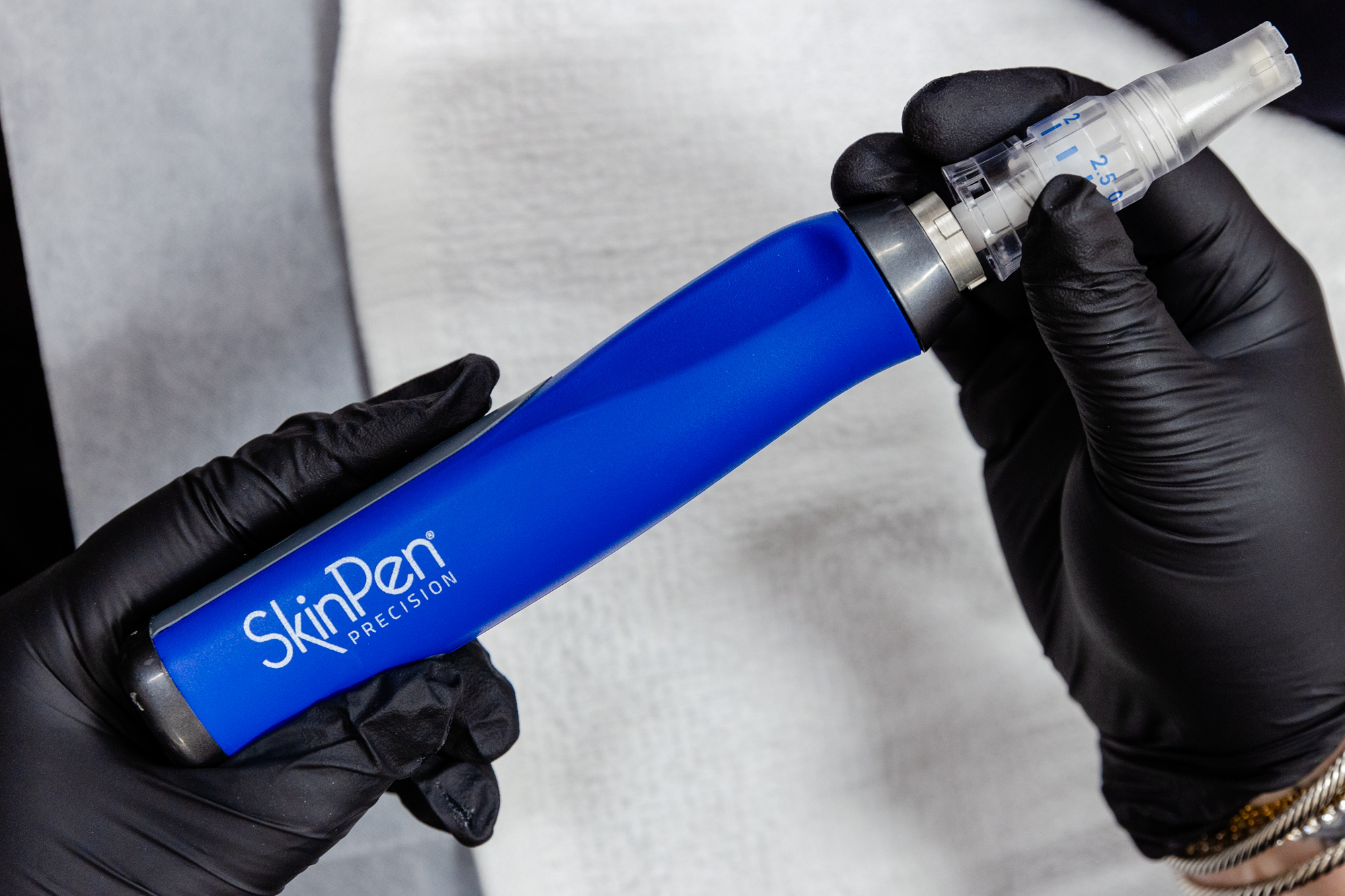 Gloved hand holding microneedle