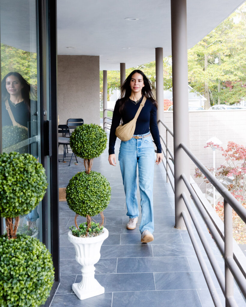 Front angle of woman walking into the front door of Exhibit Medical Aesthetics in Denville