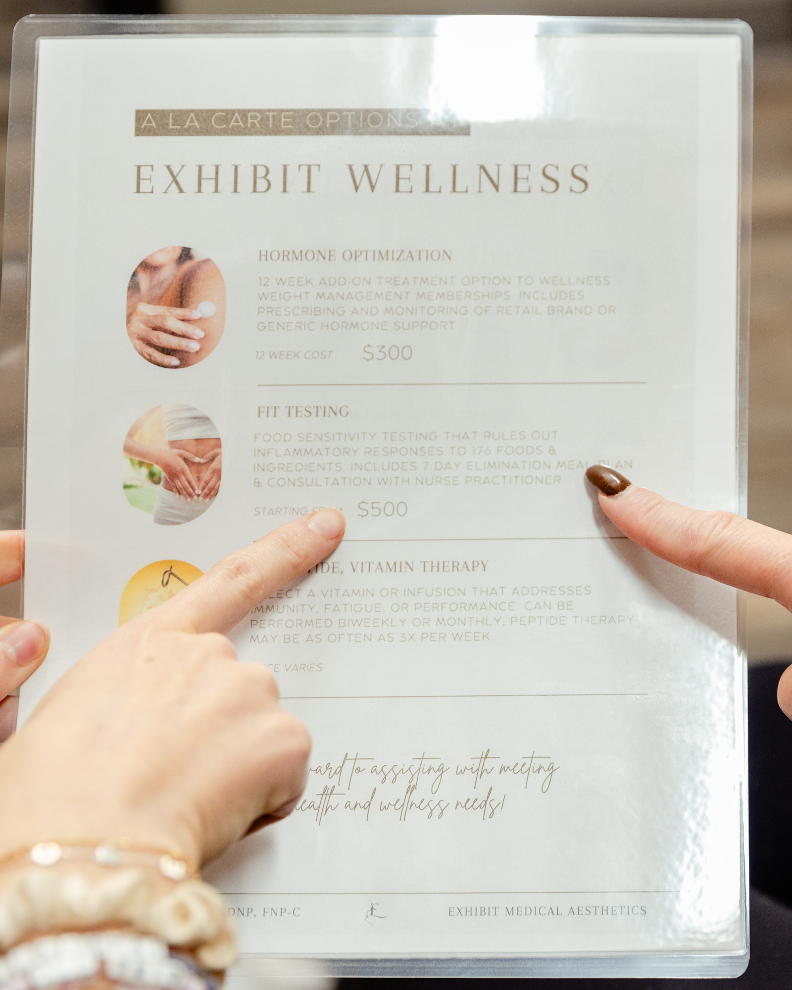 Women pointing to a menu of a la carte wellness treatments and pricing