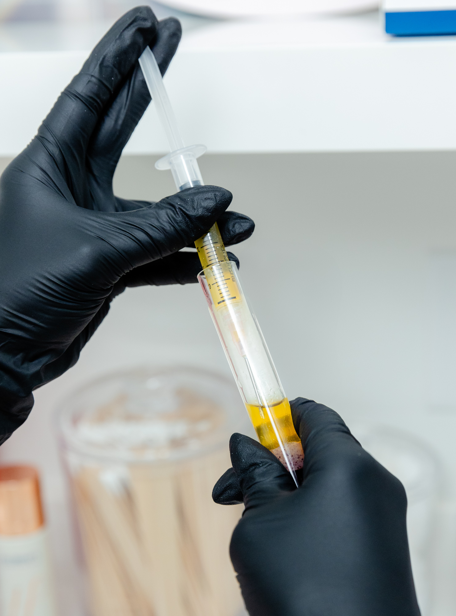 Gloved hand holding needle and syringe