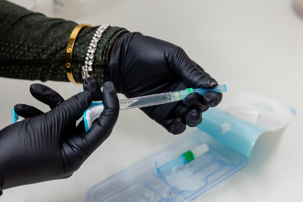 Photo of gloved hand holding needle for nose filler