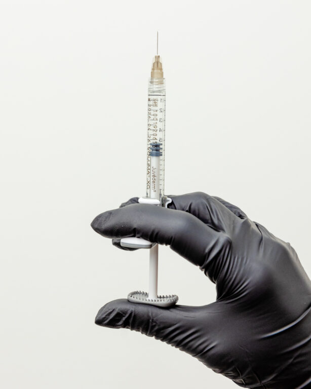 gloved hand holding needle
