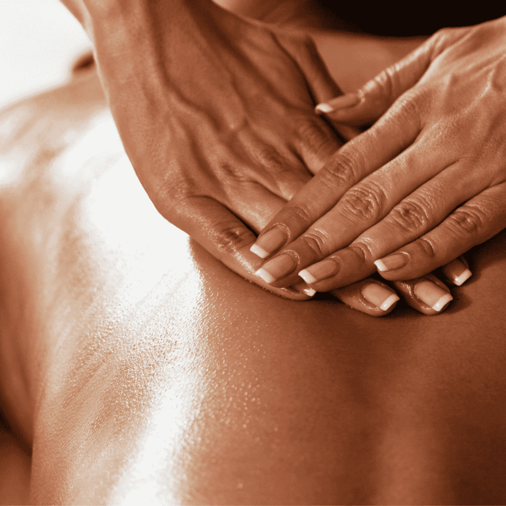 Woman giving another woman a back massage by pressing her hands into the middle of clients back.