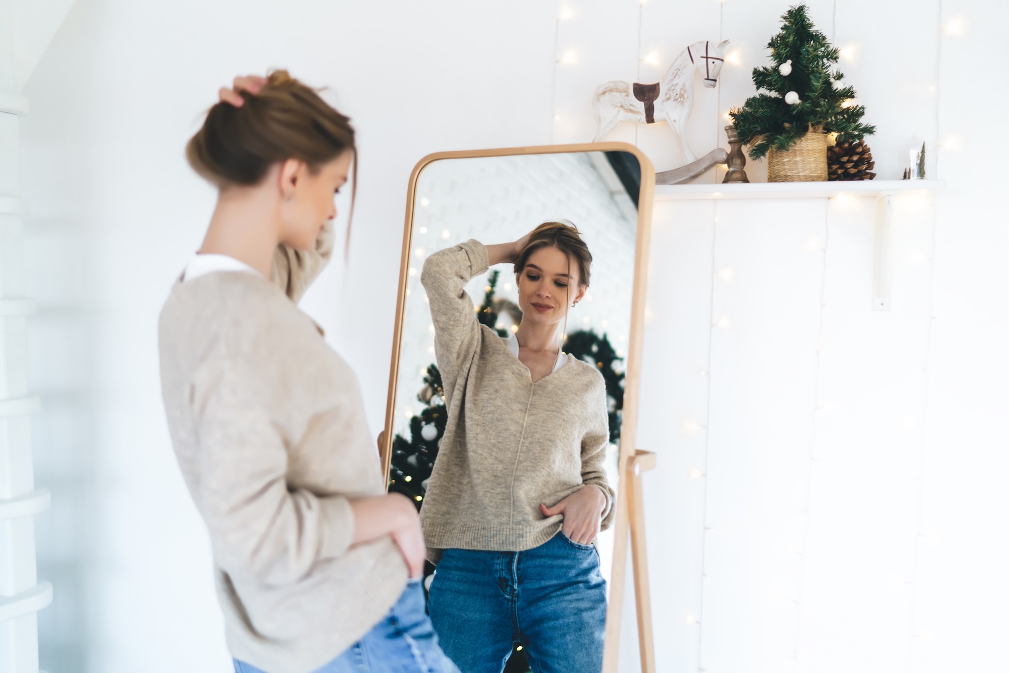 A woman examines her stomach in the mirror after starting pregnancy-safe skin care in Denville.
