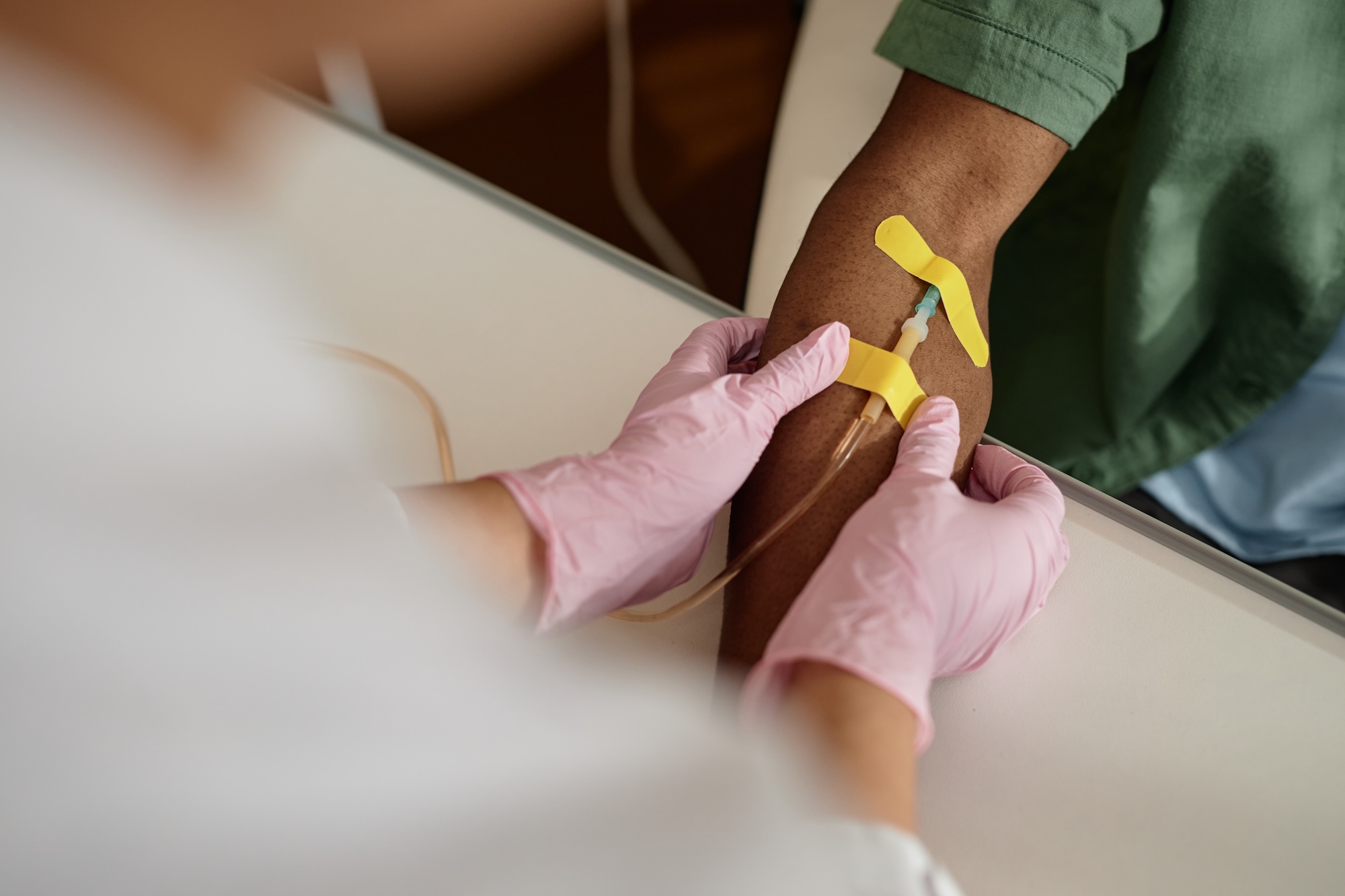 Close up of doctor preparing patient for blood test or IV infusion and putting bandage on arm copy space