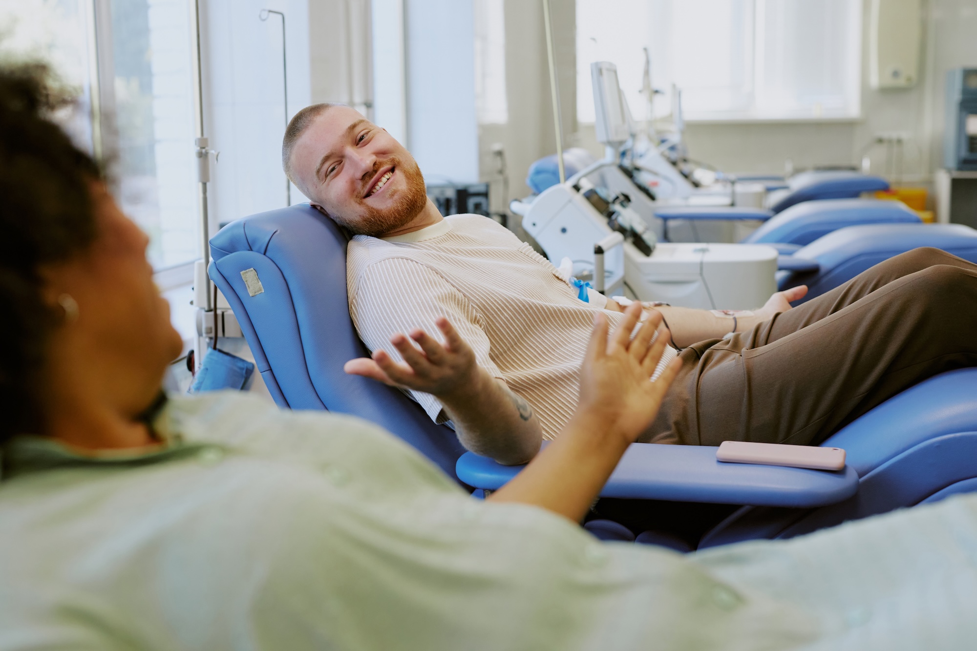 Image of two patients at Exhibit Medical Aesthetics talking to one another while they are receiving the immunity IV in Denville. 