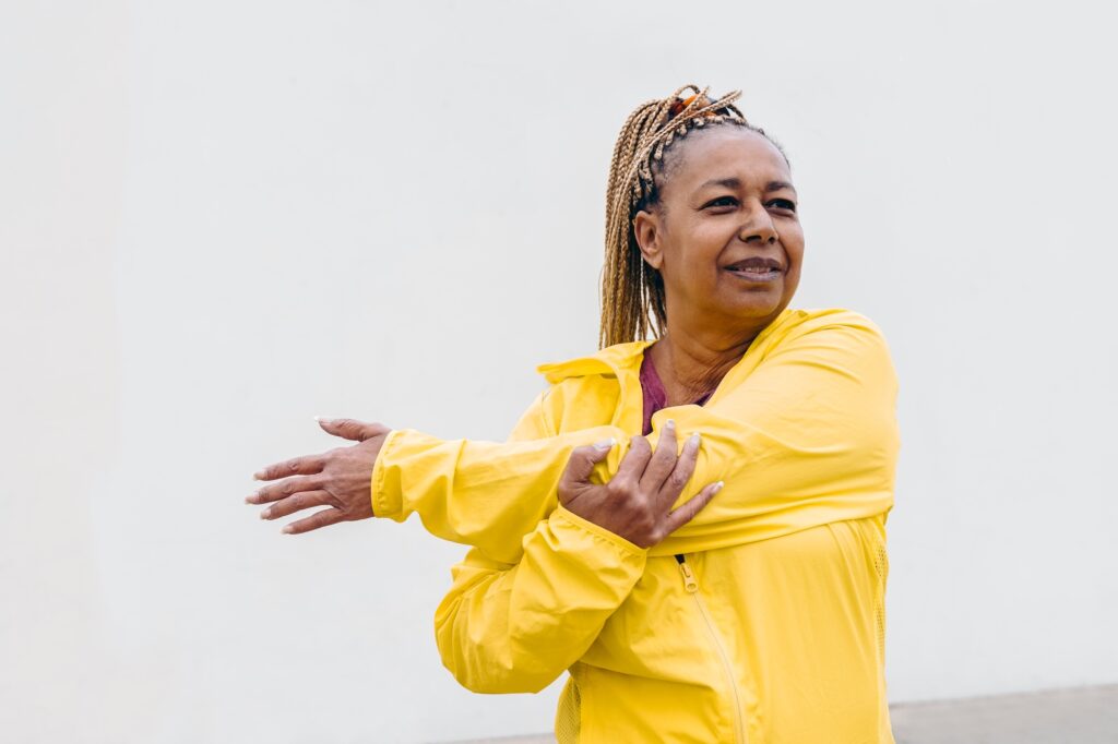 African senior woman doing workout routine while stretching outdoor after losing weight with semaglutide in Denville