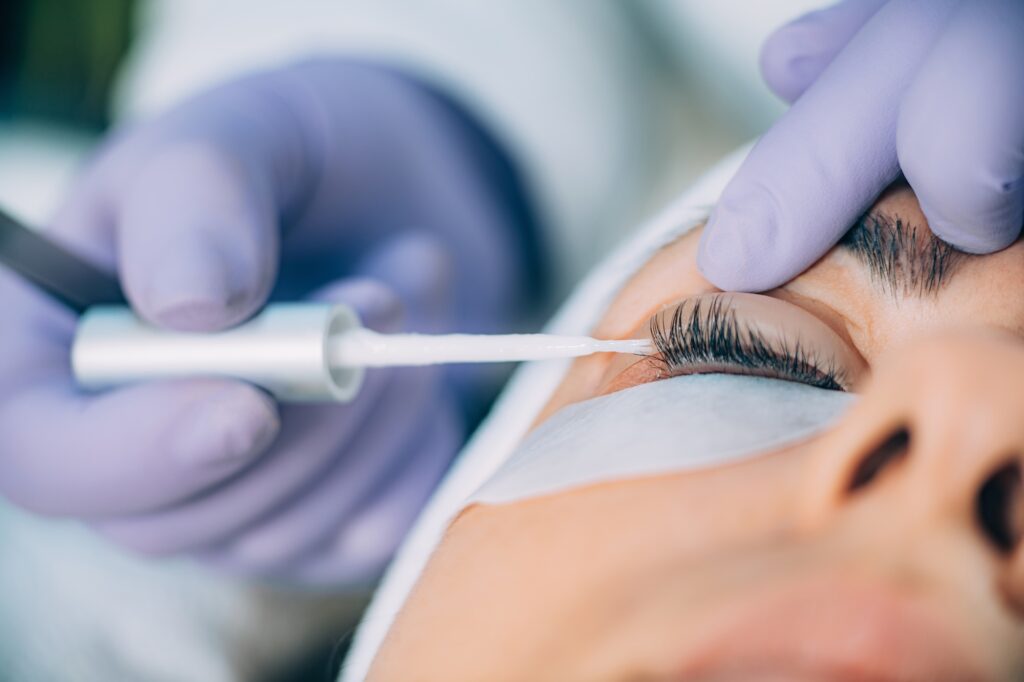 A patient lies down with their eyes closed as a provider completes their lash lift near Madison, NJ.